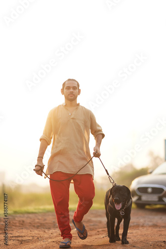 Young man and Dog Walking together in moring Training Labrador Dog