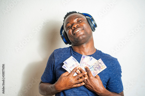 Quadro su tela image of african guy, with bank note, head phone- ghana cedis notes