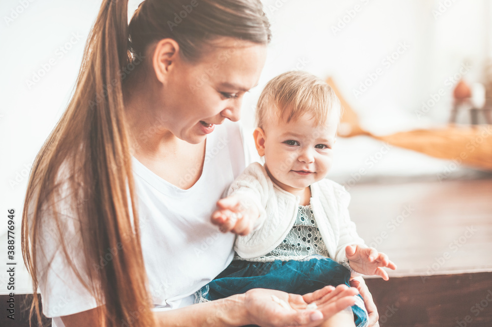 Naklejka premium Mom and baby are sitting at home and smiling cheerfully