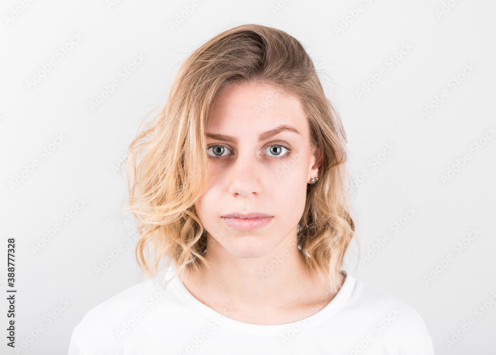Studio shot of cute blonde girl with thoughtful and sly expression, raising one brow Studio shot of cute blonde girl with thoughtful and sly expression, raising one brow