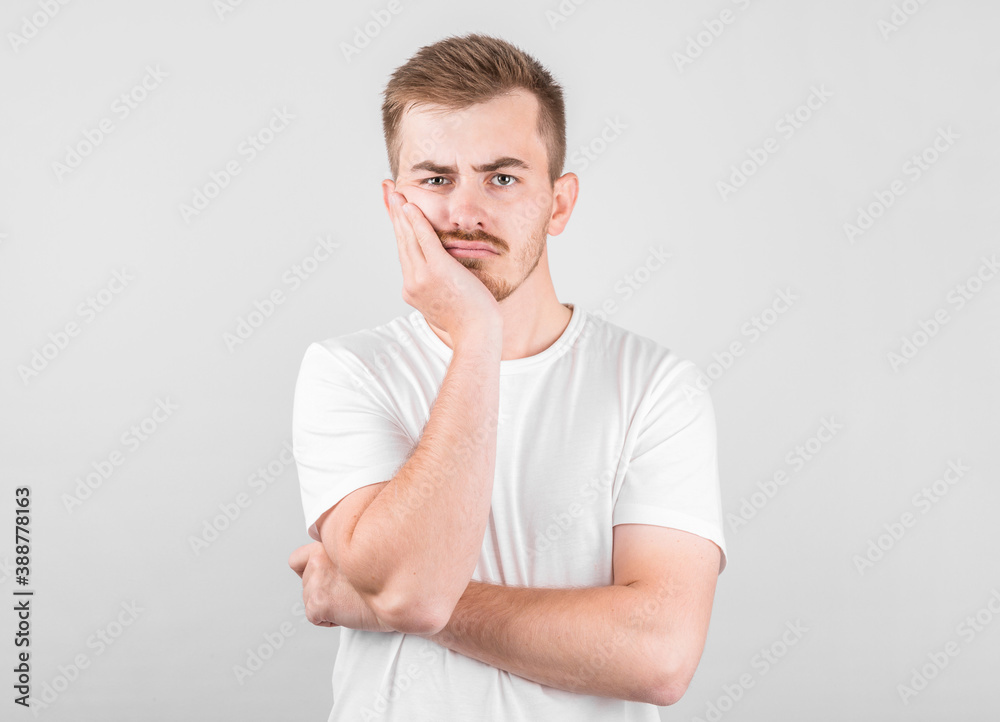 Young man with an expression of discontent on his face Young man with an expression of discontent on his face