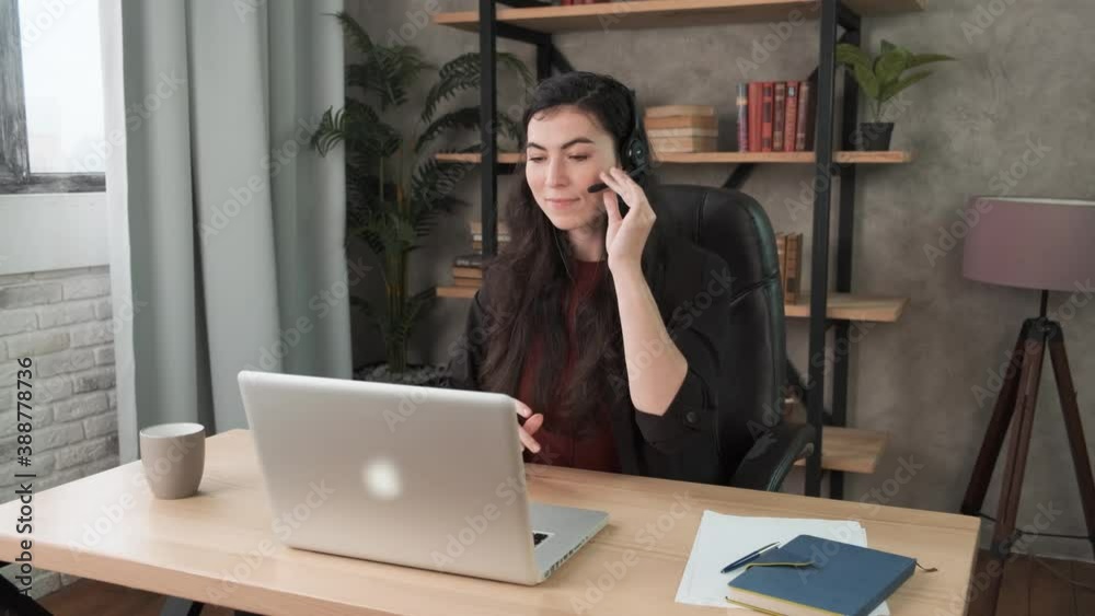 Confident woman wearing headset. Call center agent consult business client online using laptop. Brunette businesswoman in headphones working in office. Distance work webcam. Coronavirus health care 4k Confident woman wearing headset. Call center agent consult business client online using laptop. Brunette businesswoman in headphones working in office. Distance work webcam. Coronavirus health care 4k