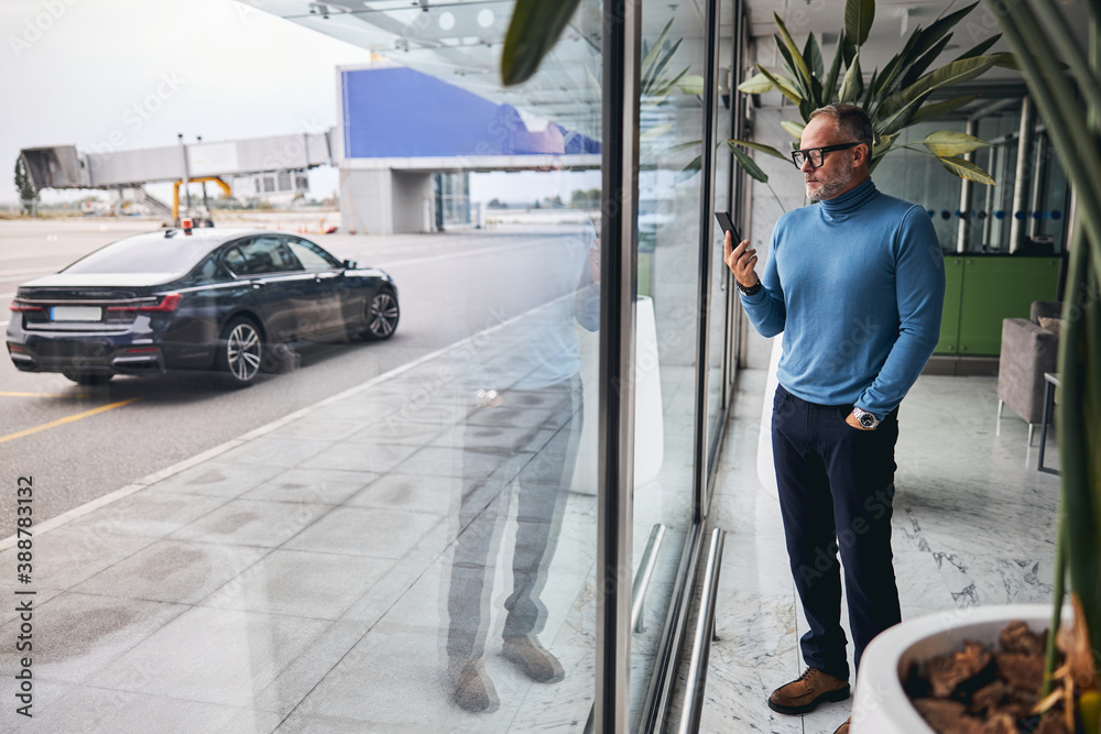 Concentrated male entrepreneur looking at his smartphone Concentrated male entrepreneur looking at his smartphone