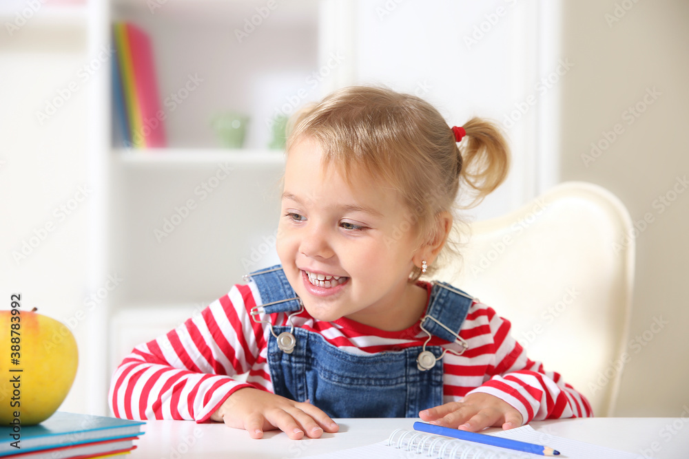 Smart caucasian kid portrait.Happy toddler sitting at desk home.Child's education. Smart caucasian kid portrait.Happy toddler sitting at desk home.Child's education.