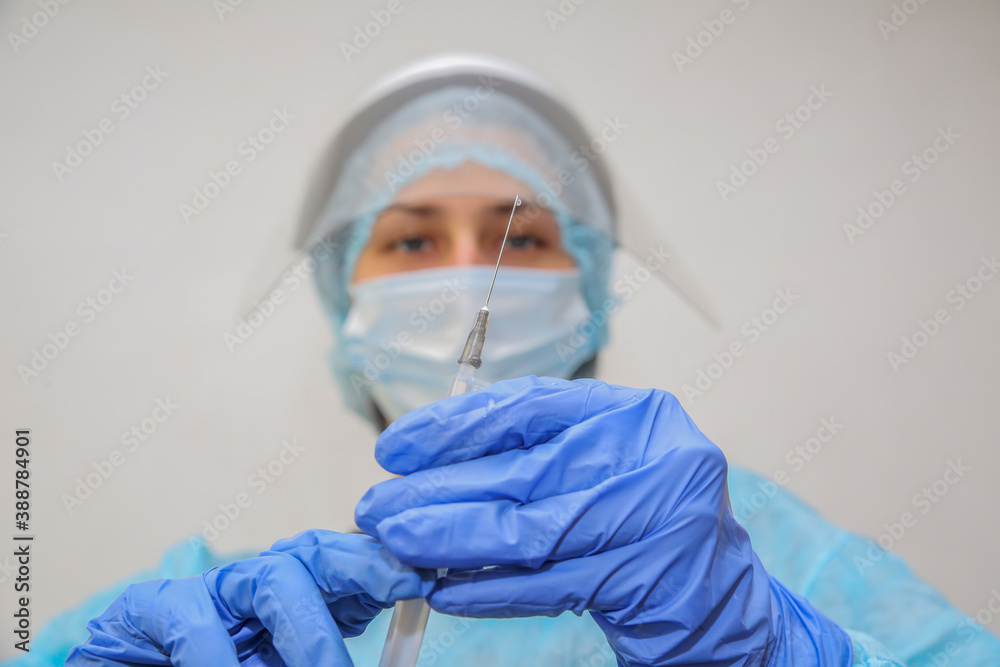 young woman doctor nurse in a protective mask with a syringe in her hand young woman doctor nurse in a protective mask with a syringe in her hand