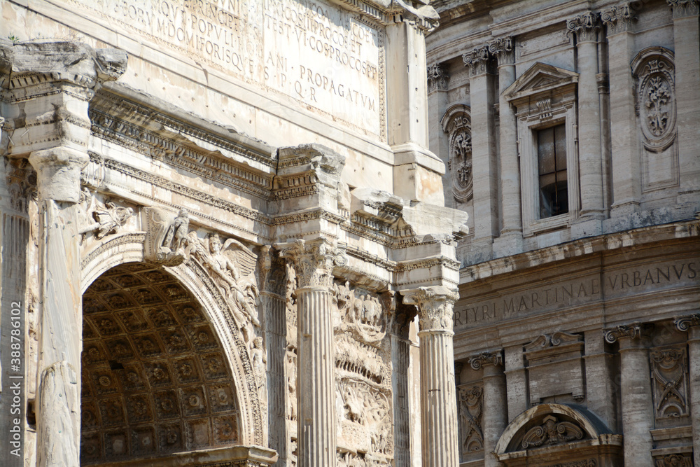 In the center of Rome, the ancient Roman Forum with the Septimius Severus Arch and the Baroque facade of the Saints Luca e Martina church.