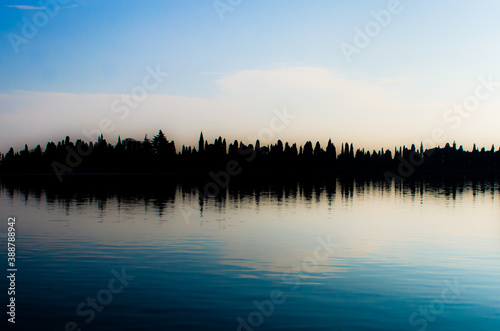 I cipressi dell'isola monastero di San Francesco del Deserto, nella laguna di Venezia, si riflettono nell'acqua immobile