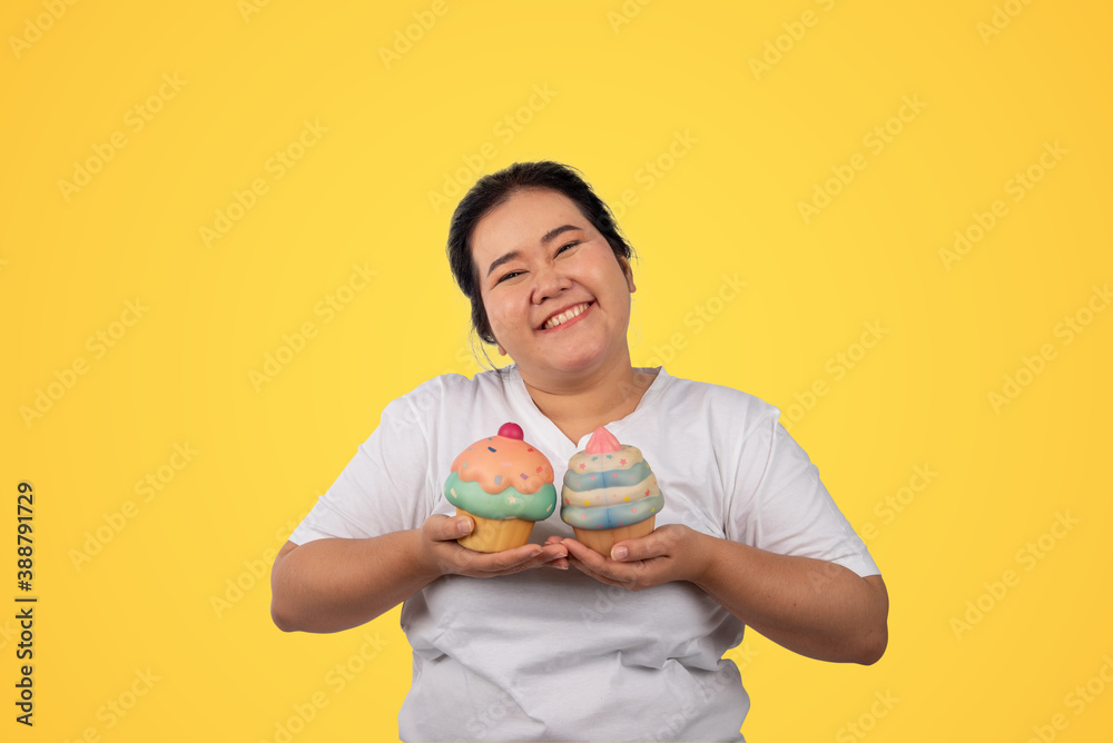 Portrait of happy young plus size  smiling on yellow background.