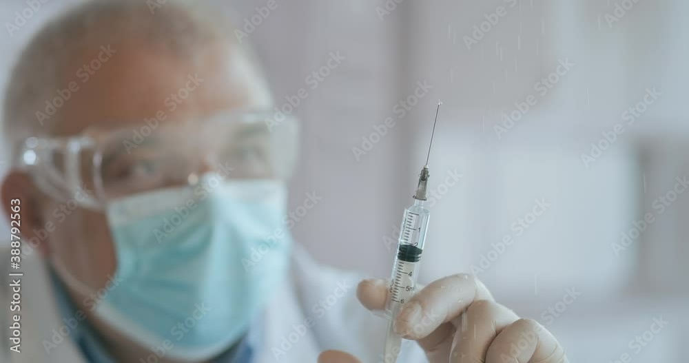 Doctor Preparing Syringe. doctor preparing syringe for injection. Female doctor or nurse holding syringe with liquid close up. Medicine and vaccination. Doctor Preparing Syringe. doctor preparing syringe for injection. Female doctor or nurse holding syringe with liquid close up. Medicine and vaccination.