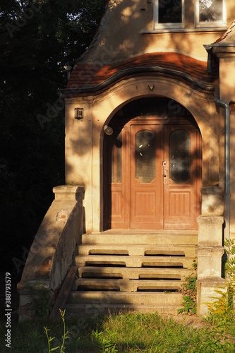 Wejściowe drzwi do starego niemieckiego domu, cień od drzewa, Wrocław, Polska