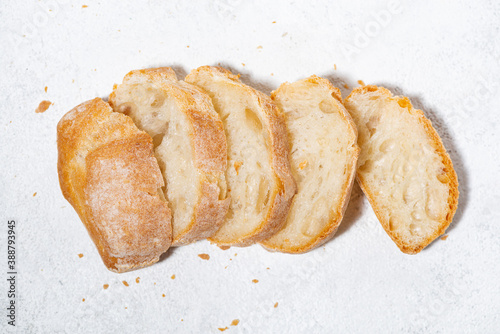 white bread cut into slices on white background, top view closeup