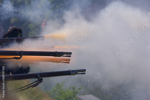 flintlock muzzle loader muskets guns firing. Smoke from the gunpowder fills the air. photo
