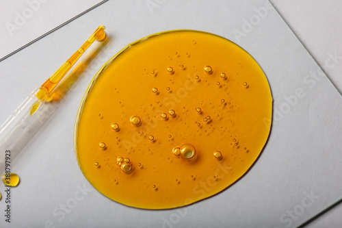 Yellow viscous liquid lecithin with bubbles on glass
