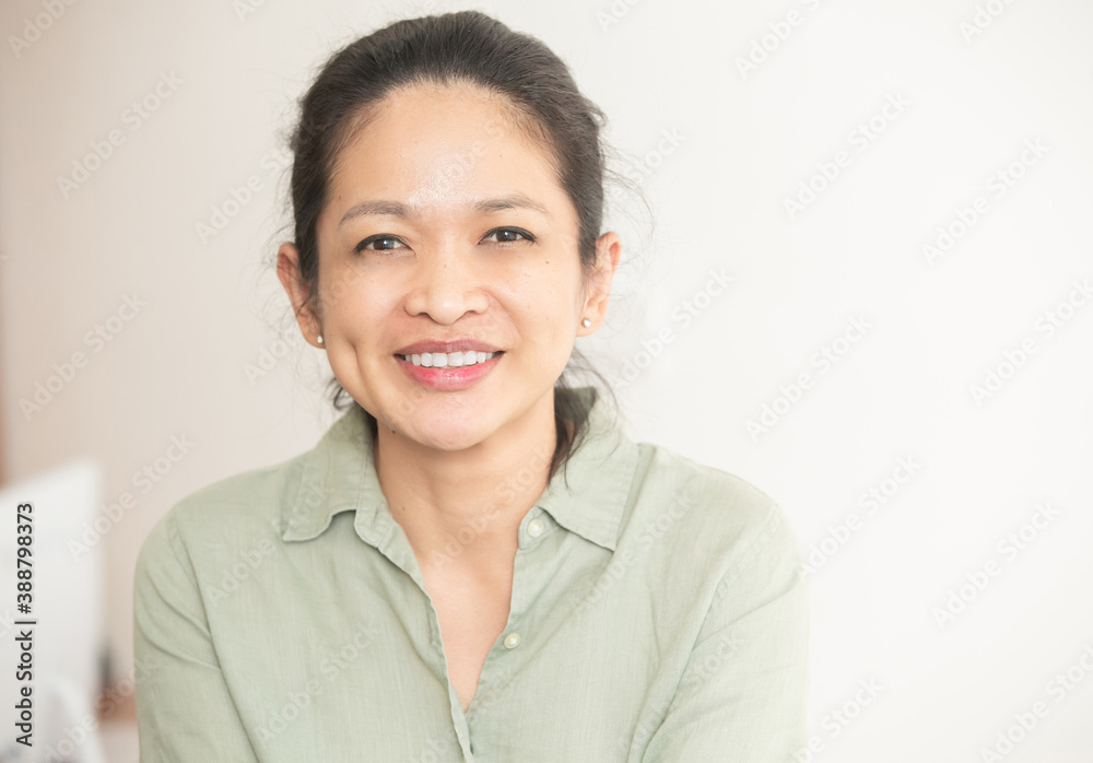 Portrait of successful mature middle age indonesian or malaysian woman over white background, Pretty businesswoman smiling and looking at camera Portrait of successful mature middle age indonesian or malaysian woman over white background, Pretty businesswoman smiling and looking at camera