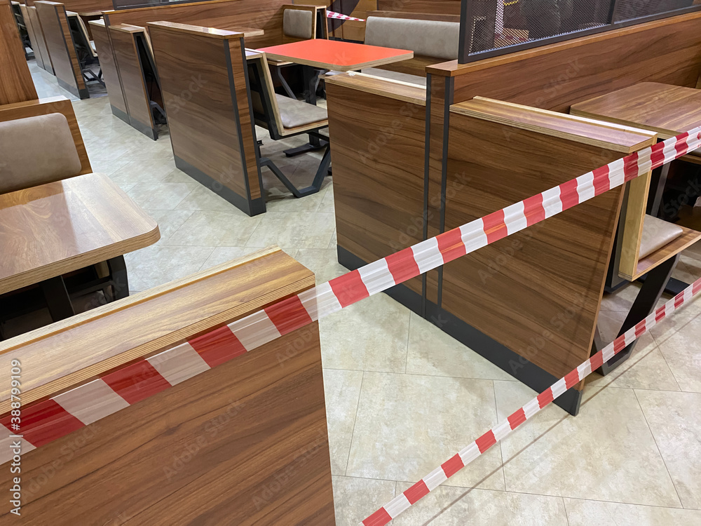 the food court of the shopping center is closed for quarantine, due to threat of coronavirus, access to restaurant, cafe is prohibited for duration of pandemic, seats are blocked with a warning tape