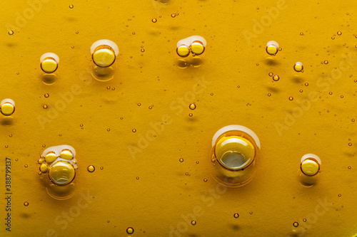 Yellow viscous liquid lecithin with bubbles on glass photo