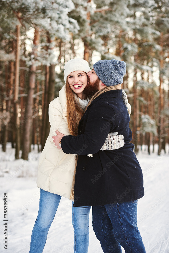 Young couple in love kiss in a winter snowy forest. Romantic relationship Young couple in love kiss in a winter snowy forest. Romantic relationship