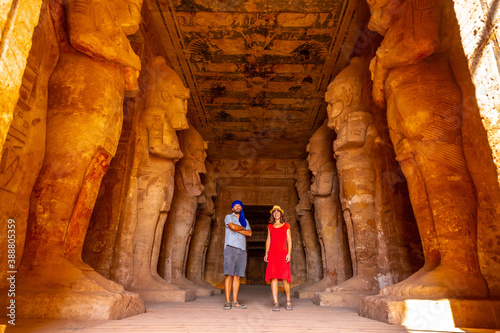 A tourist couple at the Abu Simbel Temple next to the sculptures, in southern Egypt in Nubia next to Lake Nasser. Temple of Pharaoh Ramses II, travel lifestyle