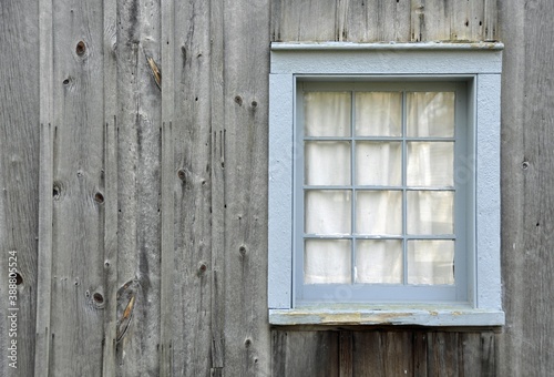 Vintage window frame and on a wooden building made of weathered wood
