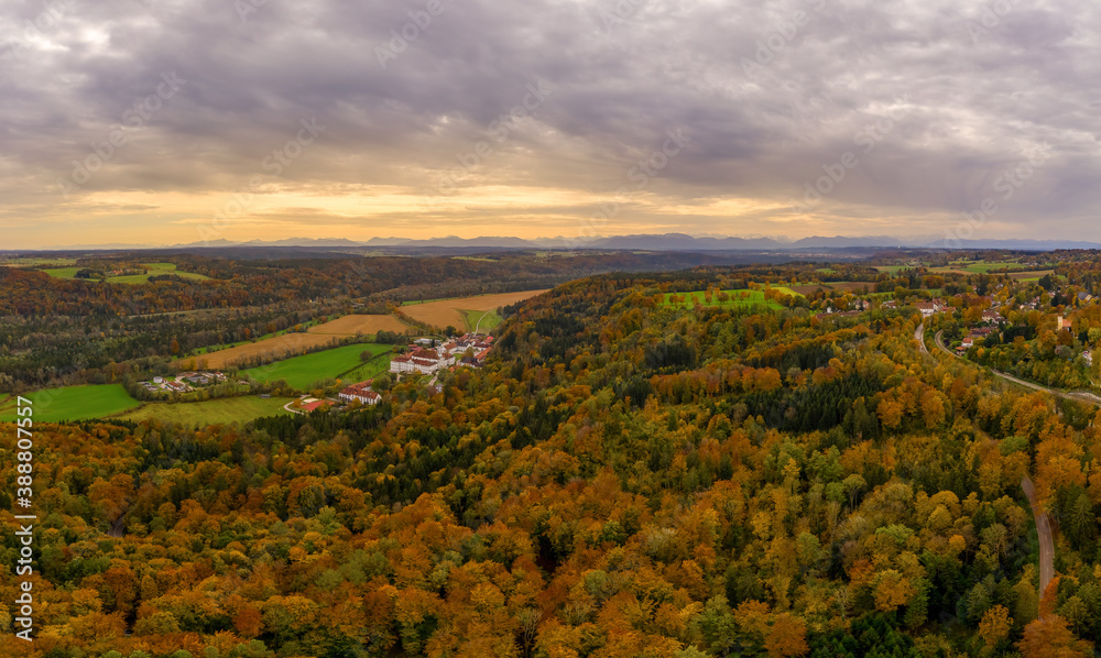 Aerial view of the forest under clouds with a monastary in the autumn.