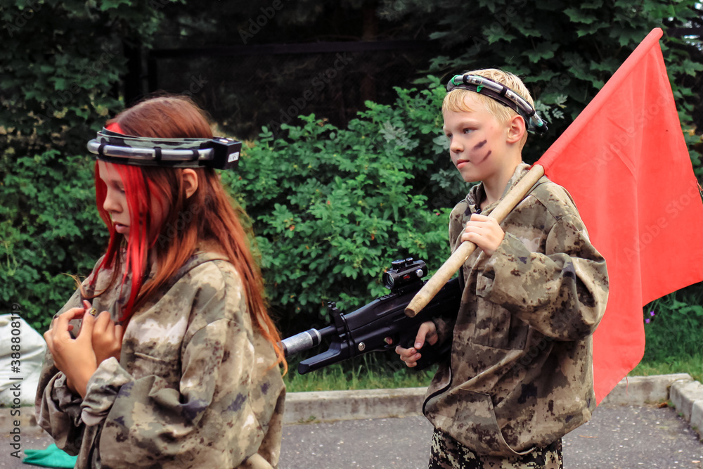 Children playing in lasertag shooting game in open air. Weapon in the hands of people. War simulation.	