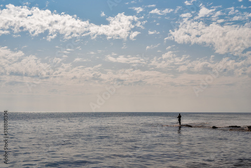 Silhouette of a fisherman fishing in the open sea. © vadimalekcandr