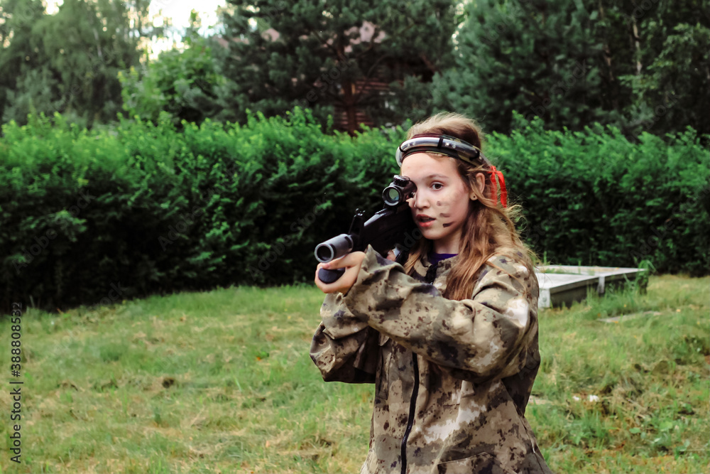 Teenage girl playing in lasertag shooting game in open air. Weapon in the hands of people. War simulation.