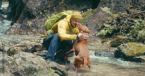 Traveler Man trekker with him dog walk around mountains in sunny day. Backpacker walking in Outdoors. Health care, authenticity, sense of balance and calmness. 4K Slow motion