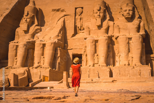 A young tourist in a red dress entering the Abu Simbel Temple in southern Egypt in Nubia next to Lake Nasser. Temple of Pharaoh Ramses II photo