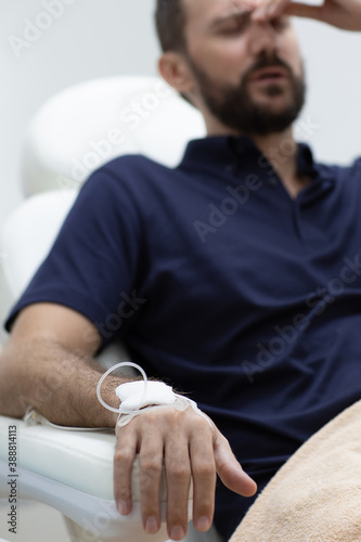 Photography Sick, dehydrated or hangover patient man receiving vitamin IV infusion drip in hospital or beauty salon