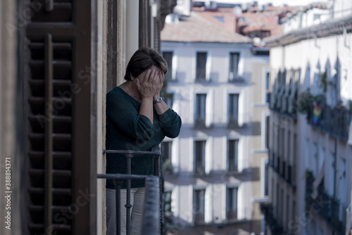 dramatic lifestyle portrait of mature woman on her 70s crying depressed and sad at home balcony feeling desperate suffering anxiety problem in senior female depression