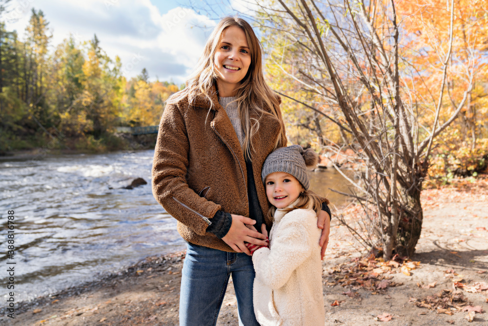 Fototapeta premium Little girl and her mother playing in the autumn park