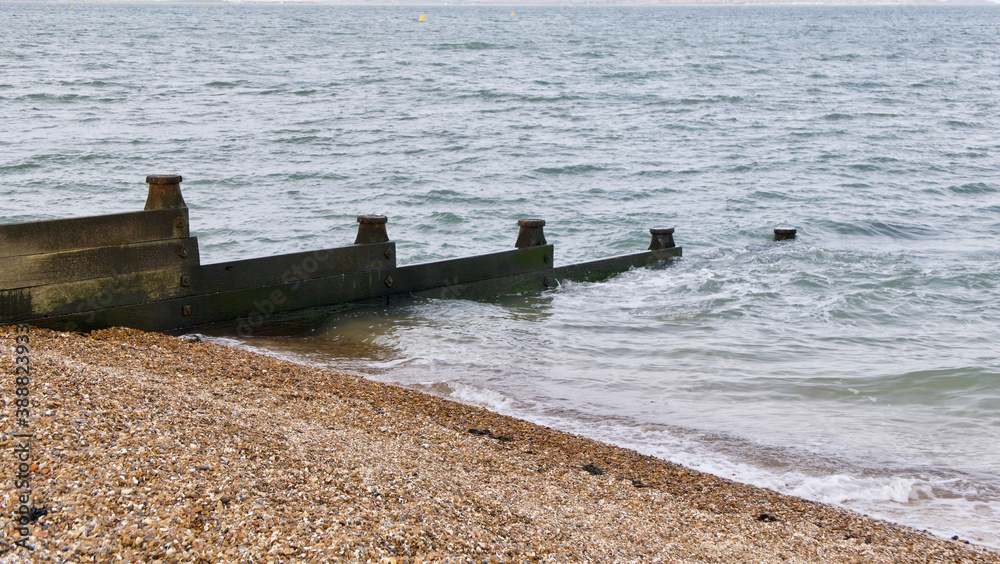 Breakwater in sea beside shingle beach with space for copy Breakwater in sea beside shingle beach with space for copy
