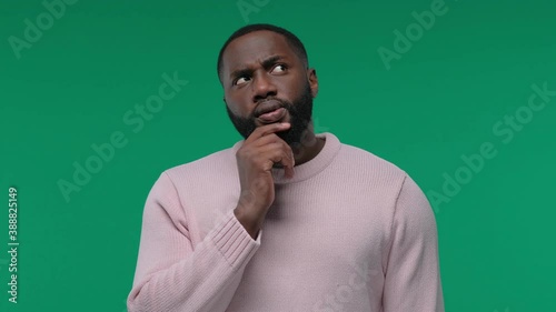 Young African American man thinking and looking up, on Green Screen, Chroma Key