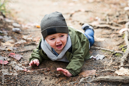 Boy hurt after falling in the forest sad and unhappy child crying