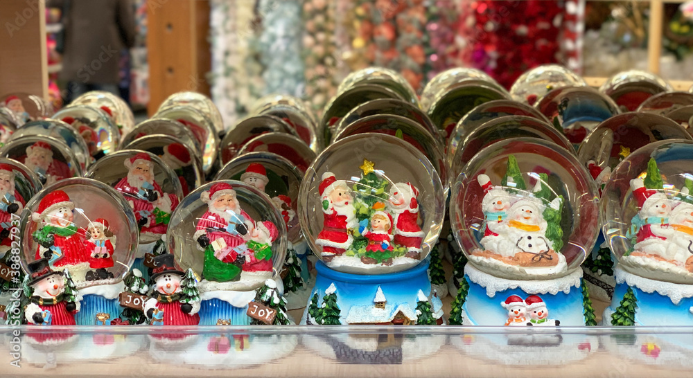 Glass balls with Santa Claus inside. Supermarket of Christmas decorations. A counter with Christmas decor.