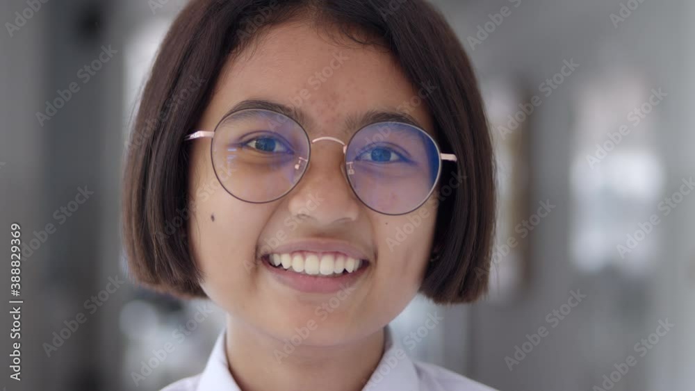 A female teenage Asian high school student in white uniform wearing glasses, short hair, is laughing happily. A female teenage Asian high school student in white uniform wearing glasses, short hair, is laughing happily.