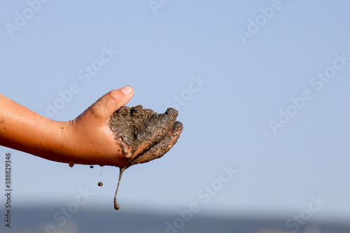 wet sea sand in kid's hand