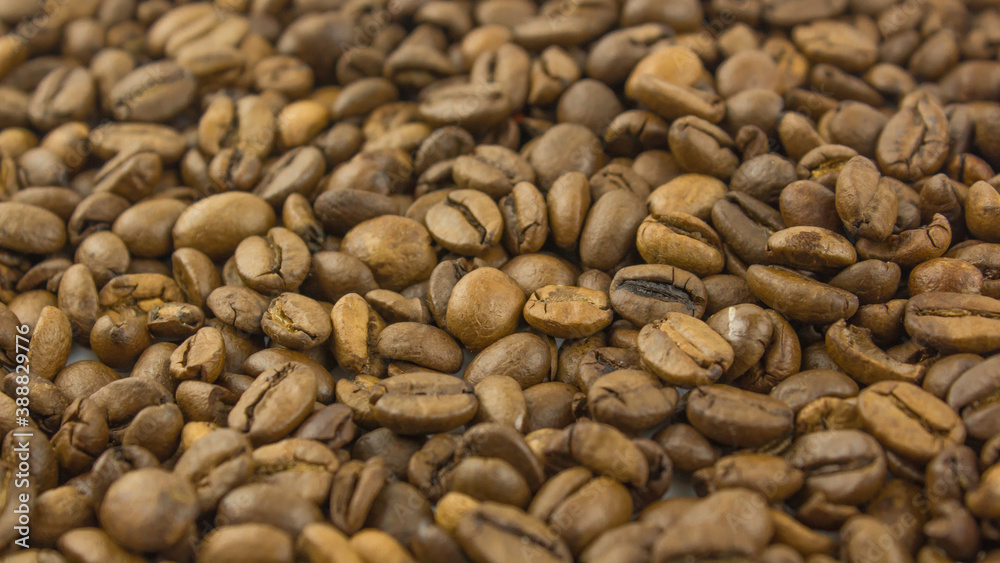 Close-up of coffee beans. Roasted grains of aromatic coffee lie on a plate. Close-up of coffee beans. Roasted grains of aromatic coffee lie on a plate.