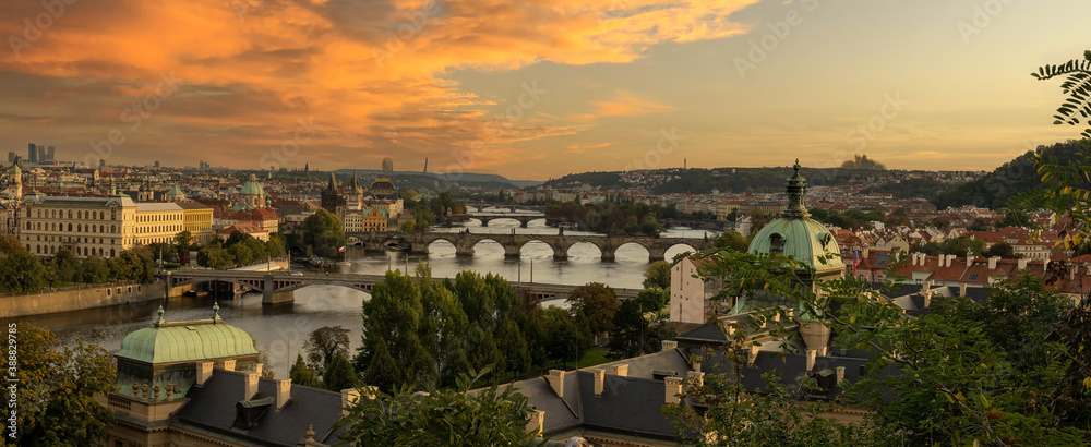 
panoramic view of the city of Prague on the Vltava river and bridges on it at sunset in spring