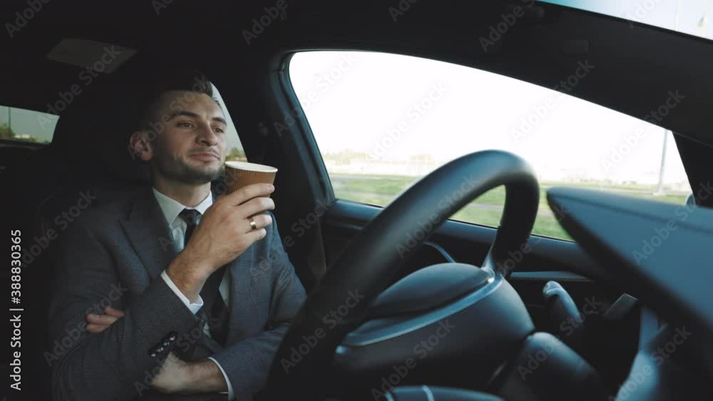Relaxed Businessman experience to riding an autonomous self driving car and drink a coffee. Vehicle starts autonomous self-driving. Concept of Driverless Future Technology in transport