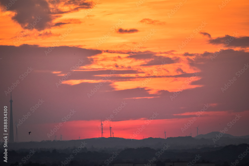 Landscape view of sunset over the city. Cloudy sky with dramatic sunset