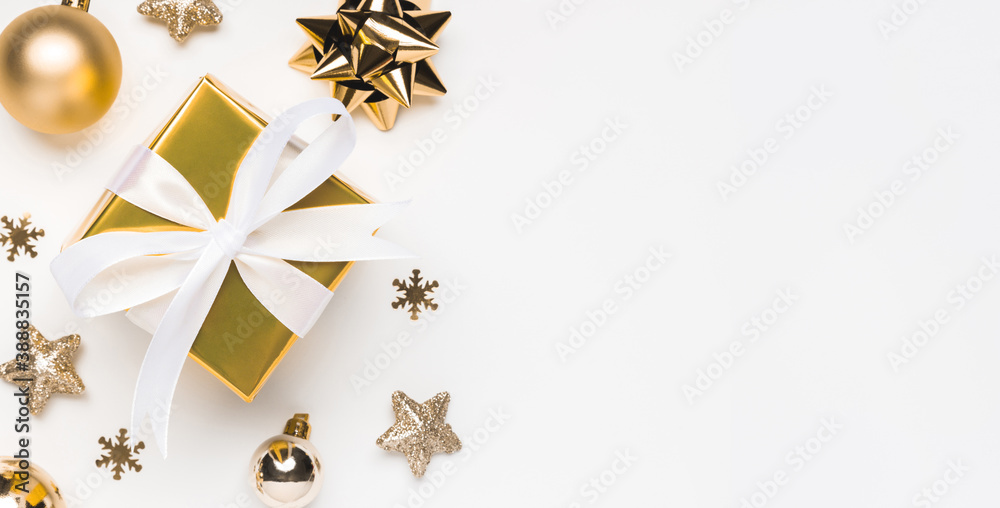Merry Christmas and Happy Holidays greeting card background with copyspace on the right. Golden Christmas gift and decor on white background top view. Winter xmas holiday theme in flat lay - obrazy, fototapety, plakaty 