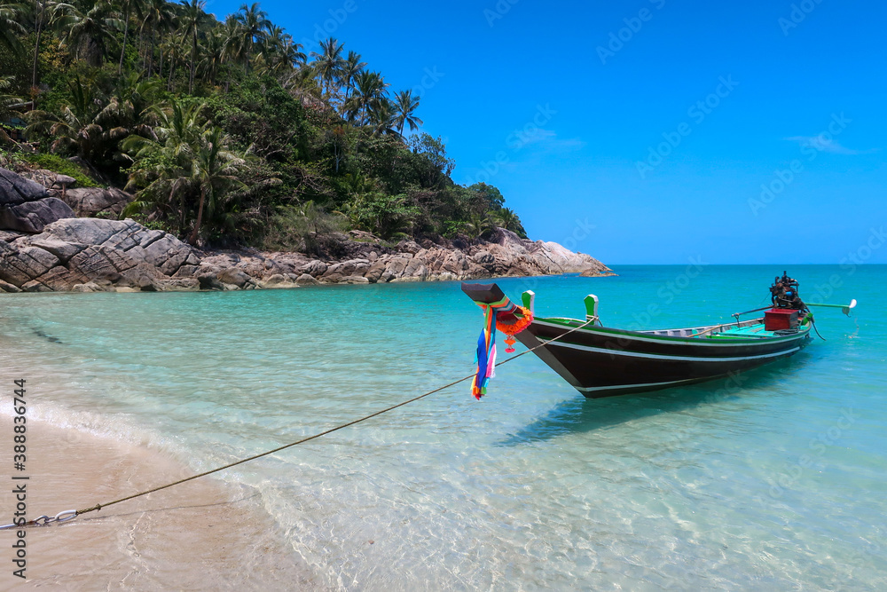 Long tail boat moored at beach in turquoise water in Koh Phangan, Thailand, Asia