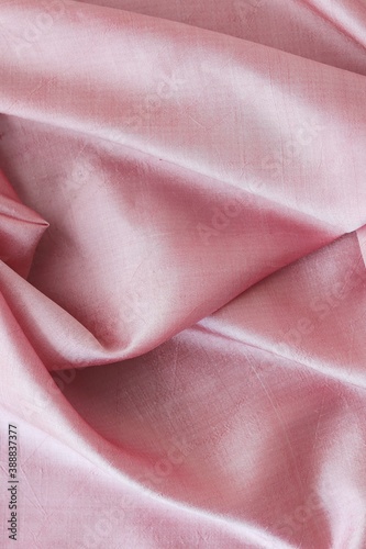 Pink fabric, natural silk lined with folds, top view, background for romantic congratulations © Tetiana