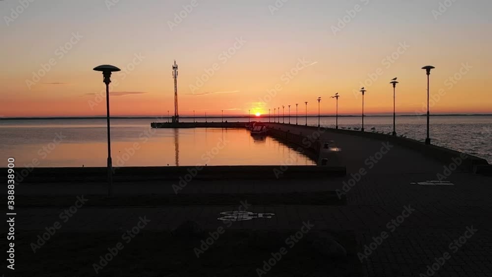 Sunset over empty pier with few yachts and birds take off, aerial slow motion. Sunset over empty pier with few yachts and birds take off, aerial slow motion.