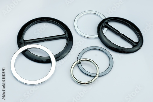 Injection molded plastic fittings for the belt of dresses or skirts. Black and gray plastic buckle for clothes. Plastic fittings on a gray background.