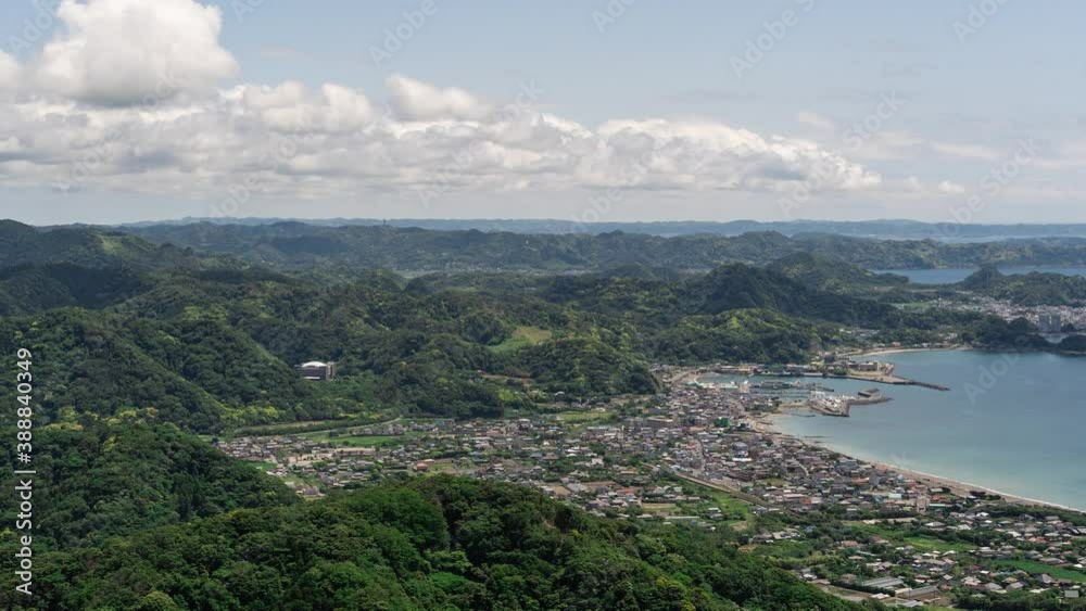Wide open timelapse over small ocean town with rolling hills, ocean and clouds - Push in shot Wide open timelapse over small ocean town with rolling hills, ocean and clouds - Push in shot