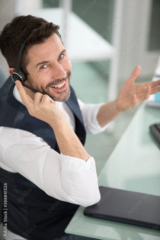 smiling man in call-centre wearing headset smiling man in call-centre wearing headset