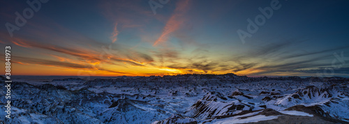 Beautiful and colorful panorama blue hour sunset over snow covered mountains and ridges of Badlands National Park.